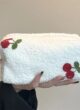 Косметичка TEDDY кремового кольору: закрита косметичка з вишнями на долоні, вид збоку