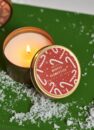 Свічка Xmas Candle Winter Clementine: запалена свічка в жерстяній банці з кришкою з льодяниками