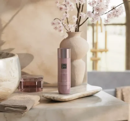 Олія для тіла Rituals Sakura Shower Oil 200 мл: рожевий флакон на кам'яній підставці біля гілок сакури