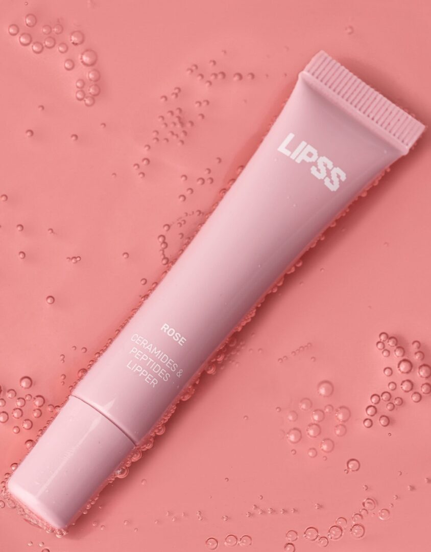 Блиск для губ LIPSS Rose 8 мл у рожевому тюбику на рожевому тлі з краплями води
