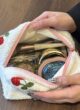 Косметичка TEDDY кремового кольору: руки відкривають косметичку з рожевою блискавкою, всередині косметика