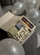 Бокс DUBAI CHARM згори: відкрита біла коробка з солодощами й чаєм на темній підлозі серед сріблястих кульок