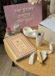 Бокс PEACEFUL LADY: щоденник, свічка-мушля та крем на столі перед табличкою The story inside the box