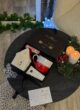 Бокс WARM KISSES: коробка зверху на круглому столі поруч із ялинковою гірляндою