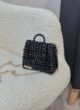 Сумка з кристалів чорна з ланцюжком золотого кольору на білому кріслі з букле