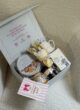 COOKIE & TEA здалеку: відкрита світла коробка з наповненням на бежевому кріслі