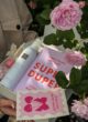 BLOSSOM BOX зблизька в руках: блокнот Everything will be Super Duper, піна Rituals і листівка з вишнями