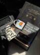 Бокс GENIUS у промені сонця: відкрита коробка з чашкою, блокнотом і листівкою біля ноутбука