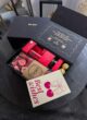 Бокс LOVE SECRET: відкрита чорна коробка на темному столі, листівка Best wishes з вишнями