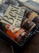 DELIGHTFUL: листівка Best wishes поверх Chivas Regal, горіхів і банок у чорній коробці