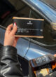 BOSS: пачка кави the box у руці на тлі синього авто, поруч пляшка Jack Daniel's