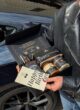 BOSS: відкрита чорна коробка з Jack Daniel's, горіхами, карамеллю та листівкою Happy Birthday у руках