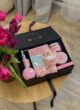 Бокс HAPPY MARCH: чорна коробка з гелем Dott, баттером, букетиком і листівкою поруч із тюльпанами