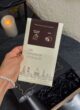 Шоколад Lviv Handmade Chocolate з молочним шоколадом і кокосом у руці над коробкою COFFEE MINI