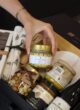 CHEESE LOVER: рука дістає банку меду Honey Room з коробки з горіхами, карамеллю та вином