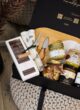 CHEESE LOVER: відкрита коробка з дошкою для сиру, ножами, рушником, шоколадом, банками меду й карамелі