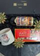 Бокс GLINTWINE BOX зблизька: пляшка Glühwein, коробка Mozart Kugeln і чашка із Сантою серед сніжинок