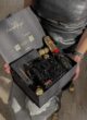 Бокс ELEGANCE у руках жінки в сріблястій сукні: чорна сумка з кристалів, Moët, цукерки Ferrero Rocher та ручка
