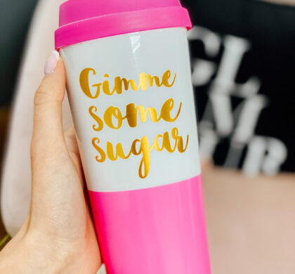 Термостакан «Gimme some sugar» у руці: рожевий стакан із золотим написом