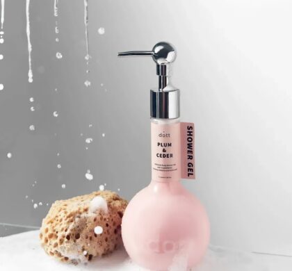 Парфумований гель для душу Dott Plum & Cedar 350 мл у круглому рожевому флаконі з дозатором поруч із губкою