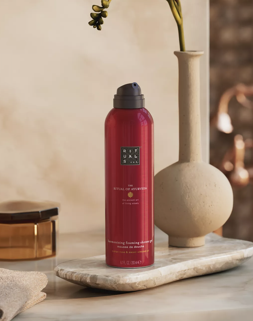 Гель-піна для душу Rituals The Ritual of Ayurveda 200 мл: червоний балончик на мармуровій таці поруч із вазою