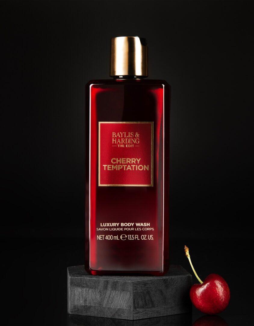 Гель для душу Baylis & Harding The Edit Cherry Temptation: червона пляшка з золотою кришкою та вишня на темному тлі