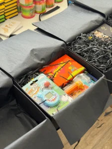 Відкриті бокси FFA з іграшками й солодощами в чорному наповнювачі