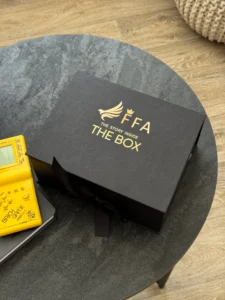 Коробка з золотим логотипом FFA і тетріс поруч