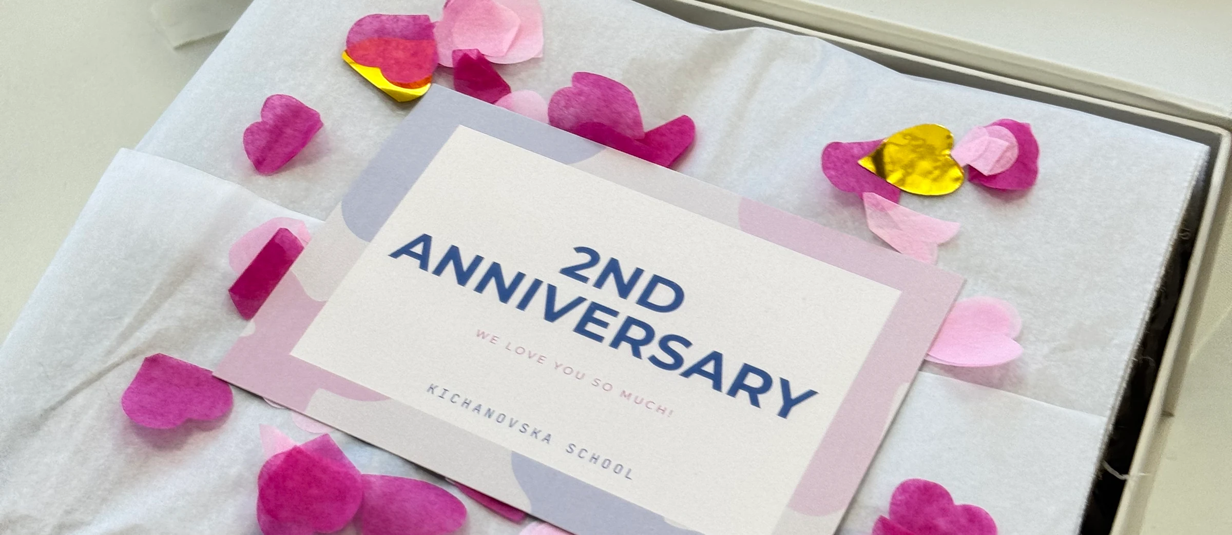 Листівка «2nd Anniversary» серед паперових сердечок у боксі KICHANOVSKA SCHOOL