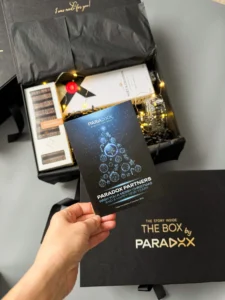 Листівка PARADOX у руці над відкритим боксом
