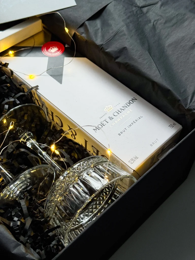 Moët і кришталеві келихи в чорному наповнювачі з гірляндою