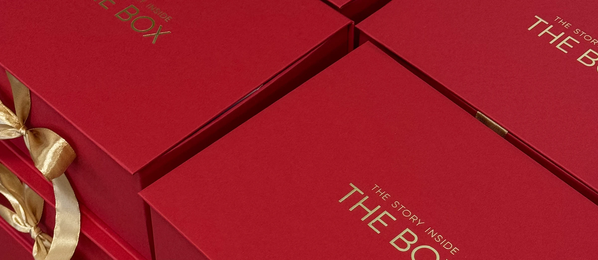 Червоні коробки The Box із золотими стрічками