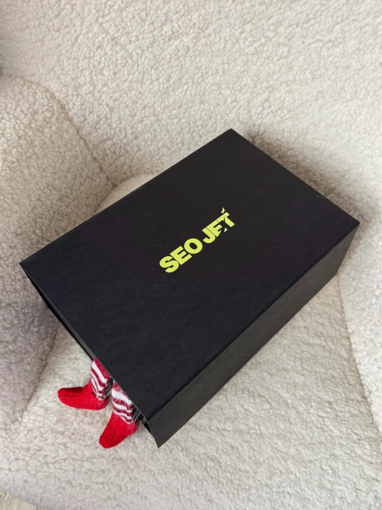 Чорна коробка SEO JET, з-під кришки визирають ніжки ельфа
