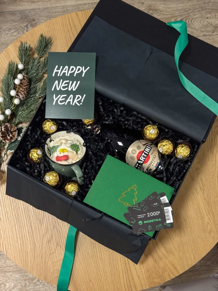 Відкритий бокс із зеленою стрічкою й листівкою «Happy New Year»